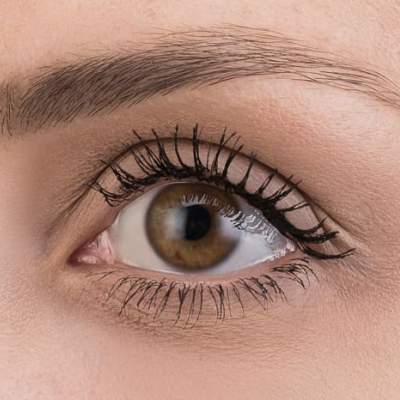 Olho castanho com pestanas maquilhadas e sobrancelha delineada