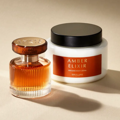 Perfume e creme corporal Amber Elixir da Oriflame sobre fundo claro