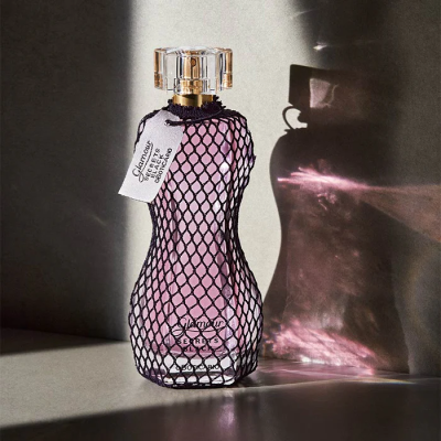 Frasco de perfume rosa com rede preta e etiqueta branca