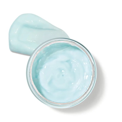 Frasco aberto com creme azul claro e amostra do creme ao lado