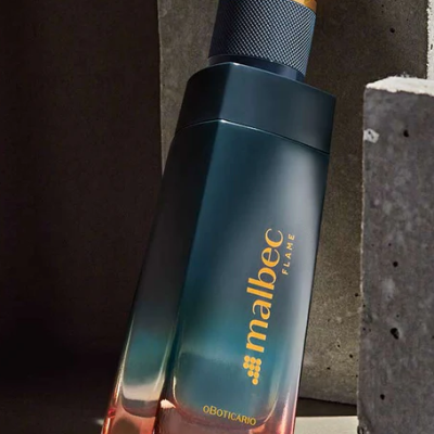 Frasco de perfume Malbec Flame azul e laranja com tampa preta e texto dourado