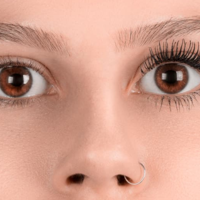 Rosto feminino em close-up com pestanas naturais e maquilhadas