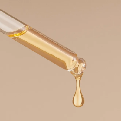 Pipeta de vidro com líquido dourado a cair