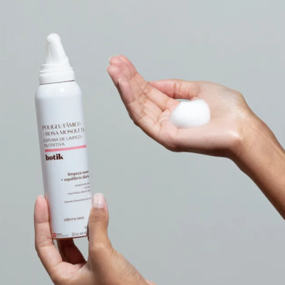 Espuma de limpeza nutritiva em embalagem branca com texto, mão segurando produto e mostrando espuma