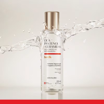 Frasco de Água Micelar Reparadora com tampa dourada e jato de água ao fundo.