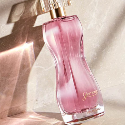 Frasco de perfume rosa com tampa transparente em superfície de mármore clara