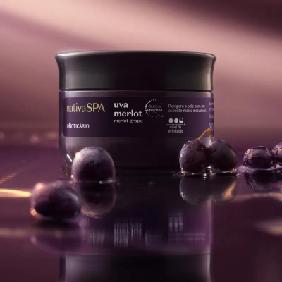Frasco de cosmético roxo rodeado por uvas em superfície brilhante
