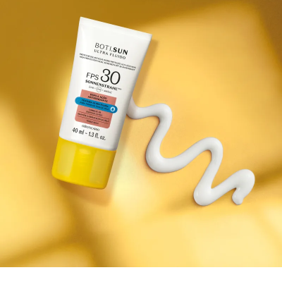 Tubo de protetor solar branco com tampa amarela e creme branco espremido ao lado