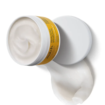 Creme nutritivo para pele em embalagem branca com rótulo amarelo e textura cremosa