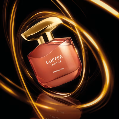 Frasco de perfume Coffee Unique Oboticario em vidro âmbar com tampa dourada e luzes douradas ao redor