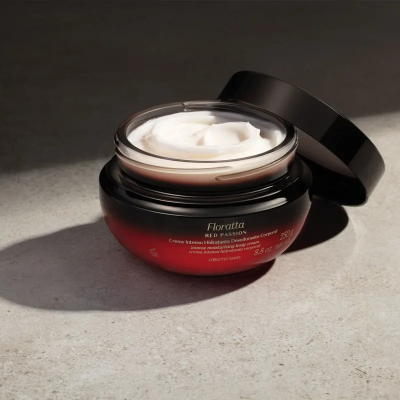 Frasco aberto de creme hidratante vermelho com tampa preta e creme branco dentro