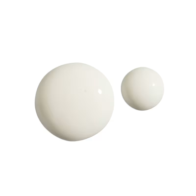 Duas gotas de líquido branco brilhante sobre fundo branco