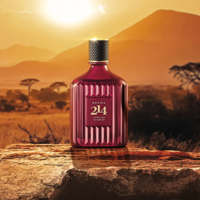 Frasco vinho de perfume Botica 214 African Sunrise sobre pedra com paisagem de pôr do sol
