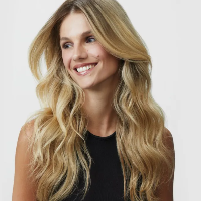 Mulher com cabelo loiro ondulado e top preto