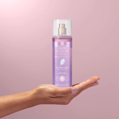 Body splash Algodão Doce O Boticário 200 ml segurado na mão com fundo rosa