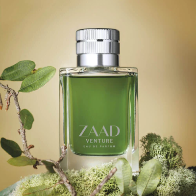Frasco de perfume verde Zaad Venture com tampa prateada sobre musgo e plantas