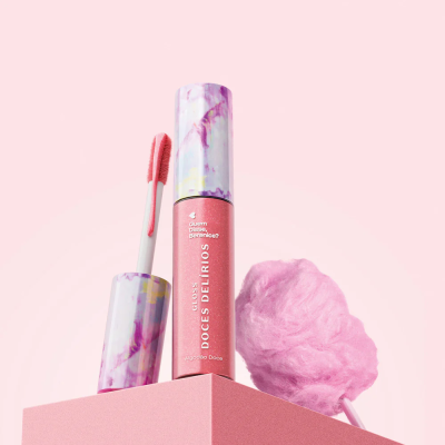 Gloss labial rosa com embalagem marmorizada e algodão doce rosa