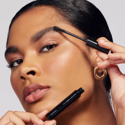 Mulher a aplicar máscara de pestanas preta