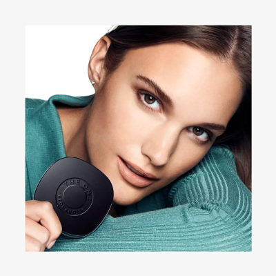 Mulher com compacto preto THE ONE STOCKHOLM e camisola verde azulada