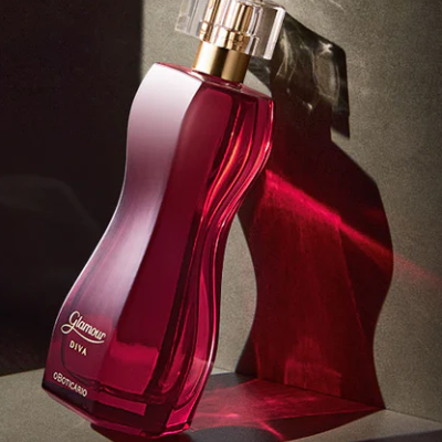 frasco de perfume vermelho translúcido com tampa transparente e detalhes dourados