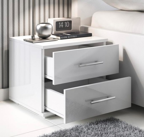 Mesa de cabeceira branca com duas gavetas e objetos decorativos sobre