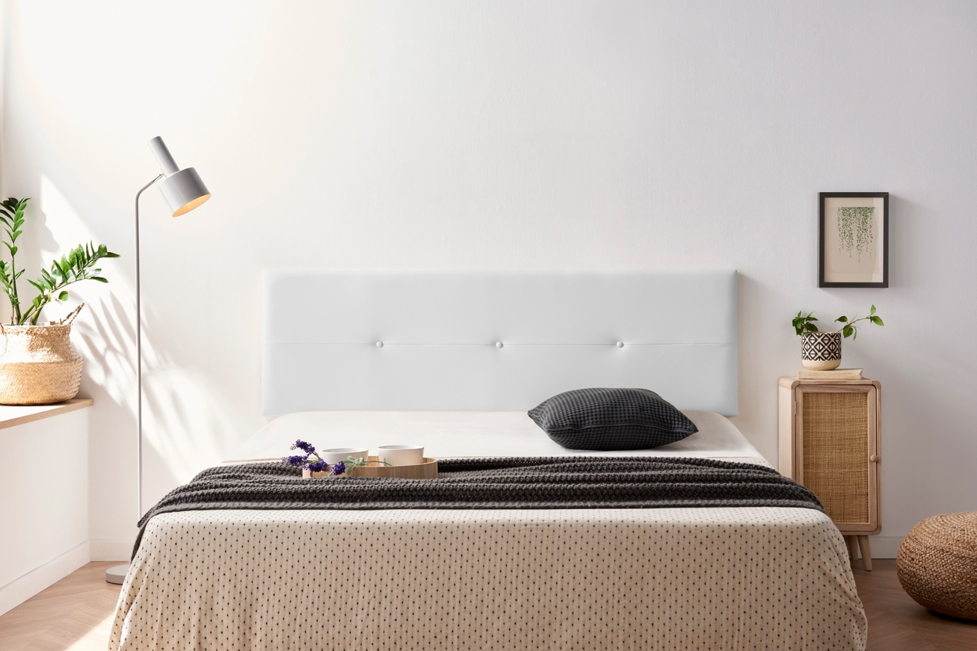 Quarto com cama branca de tecido, roupa de cama bege e cinzenta e decoração moderna