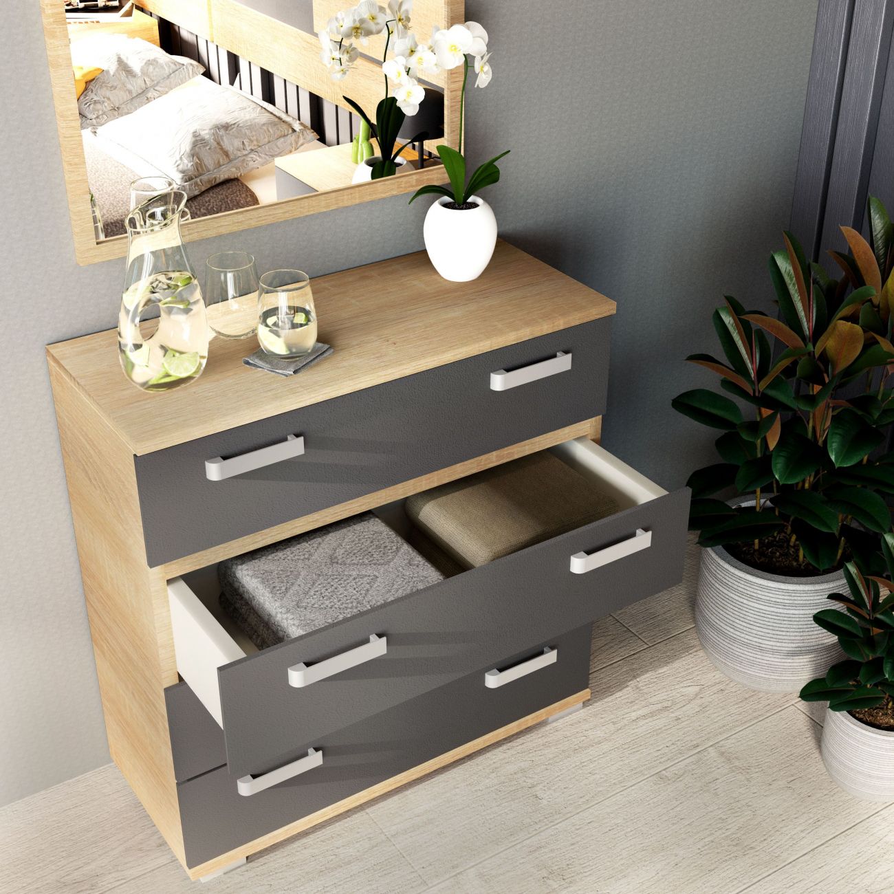 Móvel de madeira com gavetas cinzentas, jarra e copos de vidro, vaso com flores e plantas em pé
