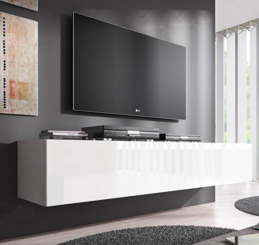 Televisor preto na parede acima de móvel branco suspenso com livros e eletrónicos