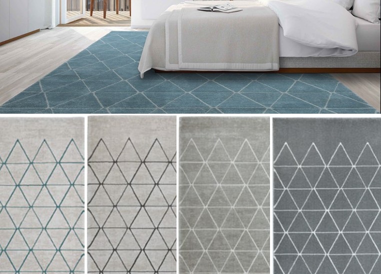 Tapete moderno com padrão de triângulos em quatro cores diferentes em ambiente de quarto com cama branca.