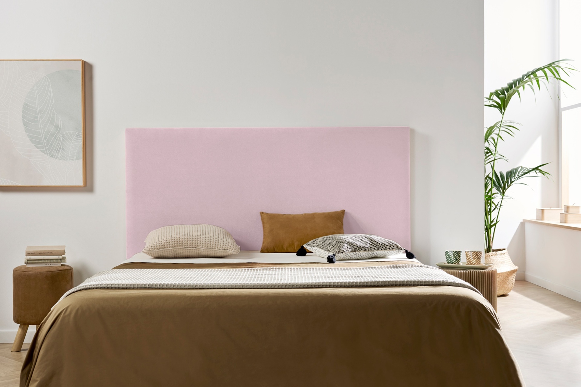 Quarto com cama de cabeceira rosa claro e roupa de cama castanha e bege