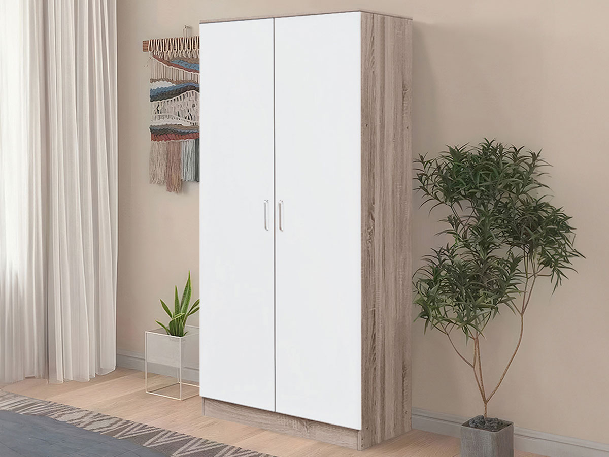 Guarda-roupa com portas brancas e laterais em madeira clara numa divisão com plantas, cortina branca e parede bege.