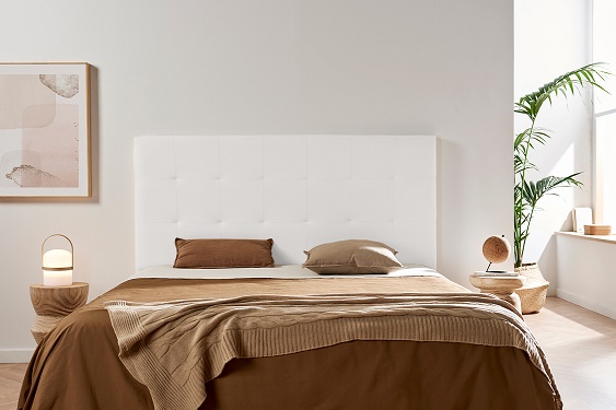 Quarto minimalista com cama e decoração em tons castanhos e bege