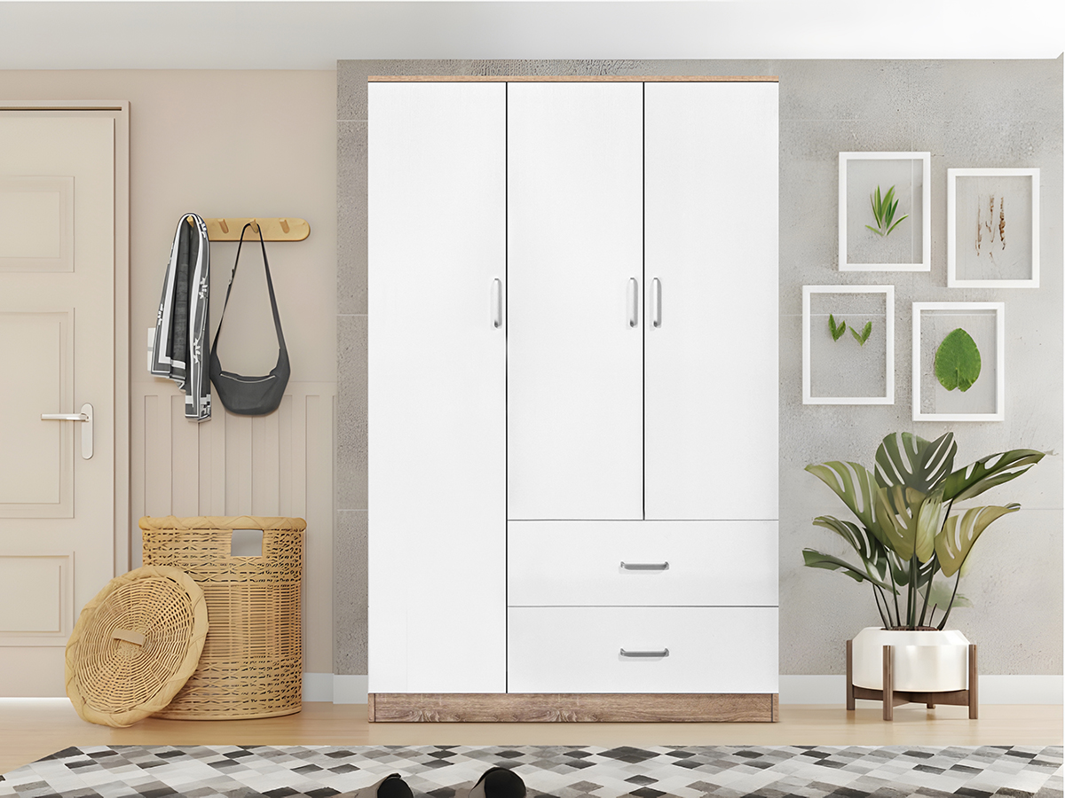 Guarda-roupa branco com três portas e duas gavetas, base de madeira, cesto de verga, planta em vaso e cabideiro na parede