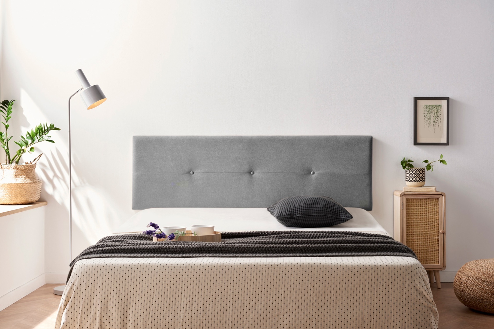 Cama com cabeceira cinzenta estofada e decoração minimalista noutro quarto
