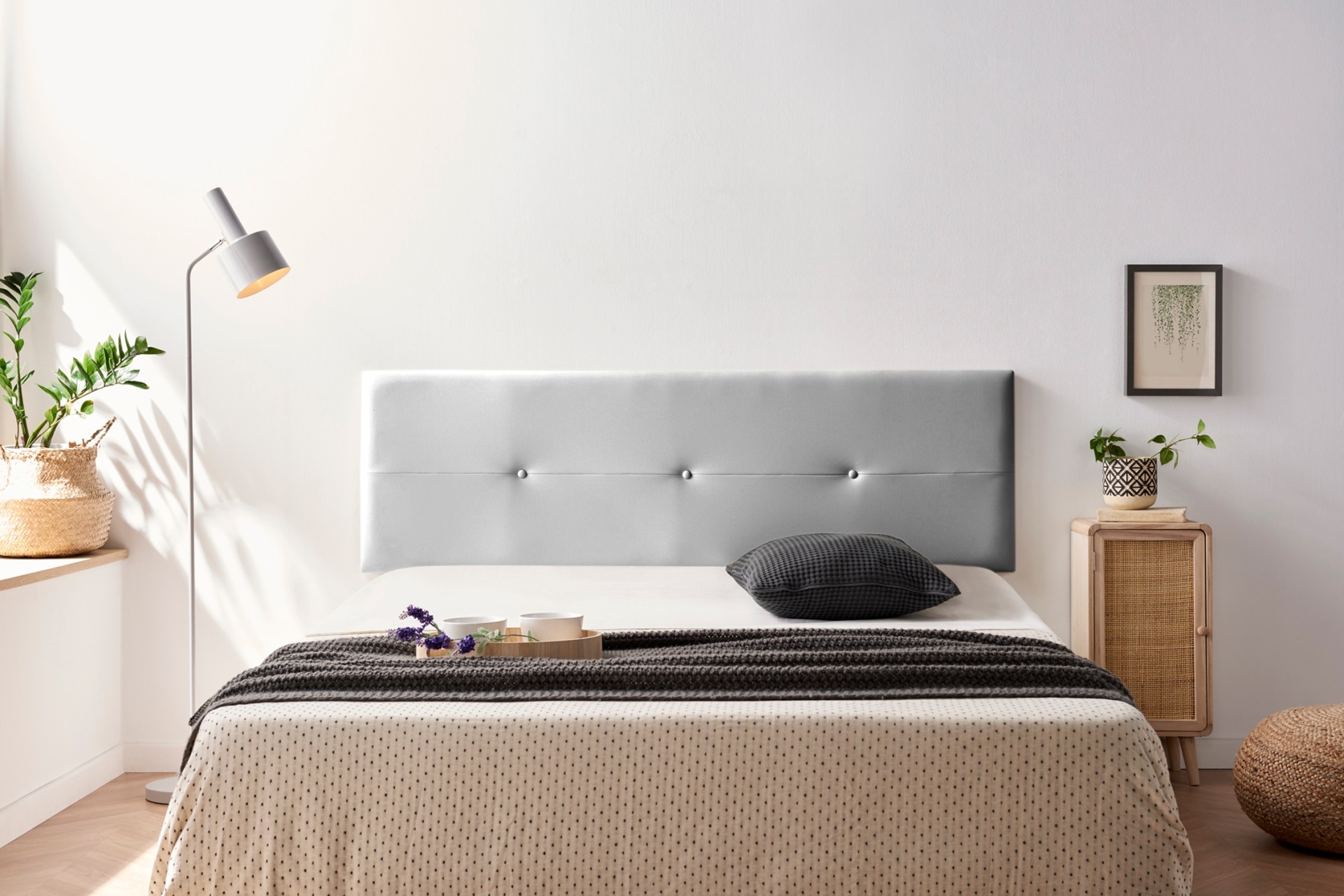 Cama de casal com cabeceira cinza claro e roupa de cama bege com padrão de pontos pretos e preto com listras brancas