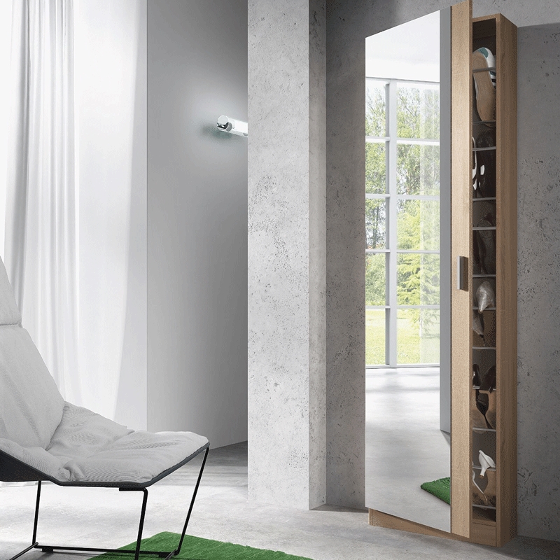 Armário espelhado estreito em madeira clara junto à parede cinza em sala moderna com poltrona branca e tapete verde