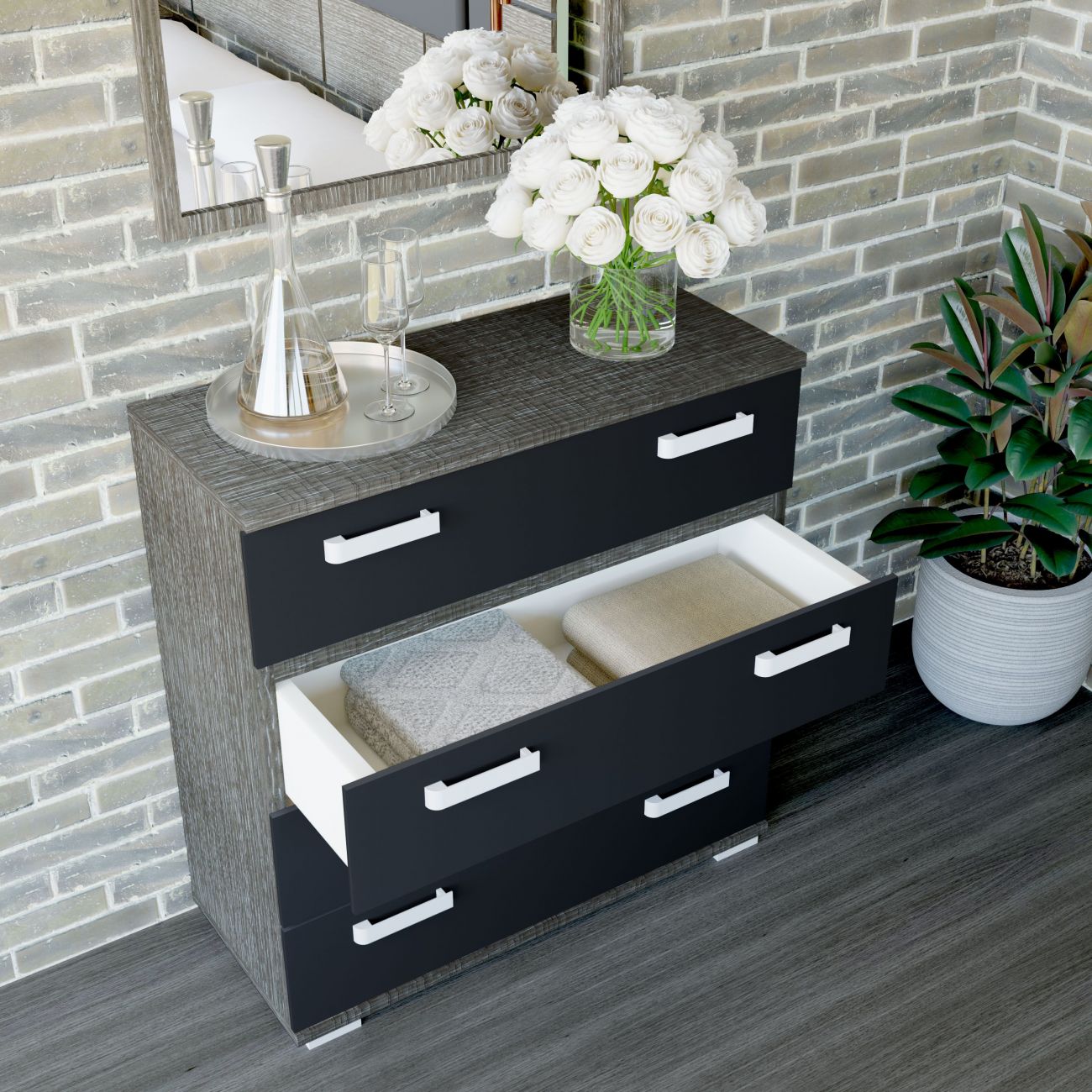 Cómoda preta com gavetas abertas, decoração com flores e jarra em ambiente com parede de tijolos cinza e planta