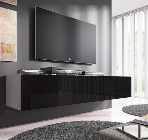 Móvel suspenso preto com TV montada na parede e eletrónicos, tapete cinzento redondo, cortinas brancas.