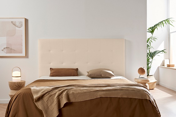 Quarto moderno com cama de cabeceira estofada bege e roupa de cama castanha