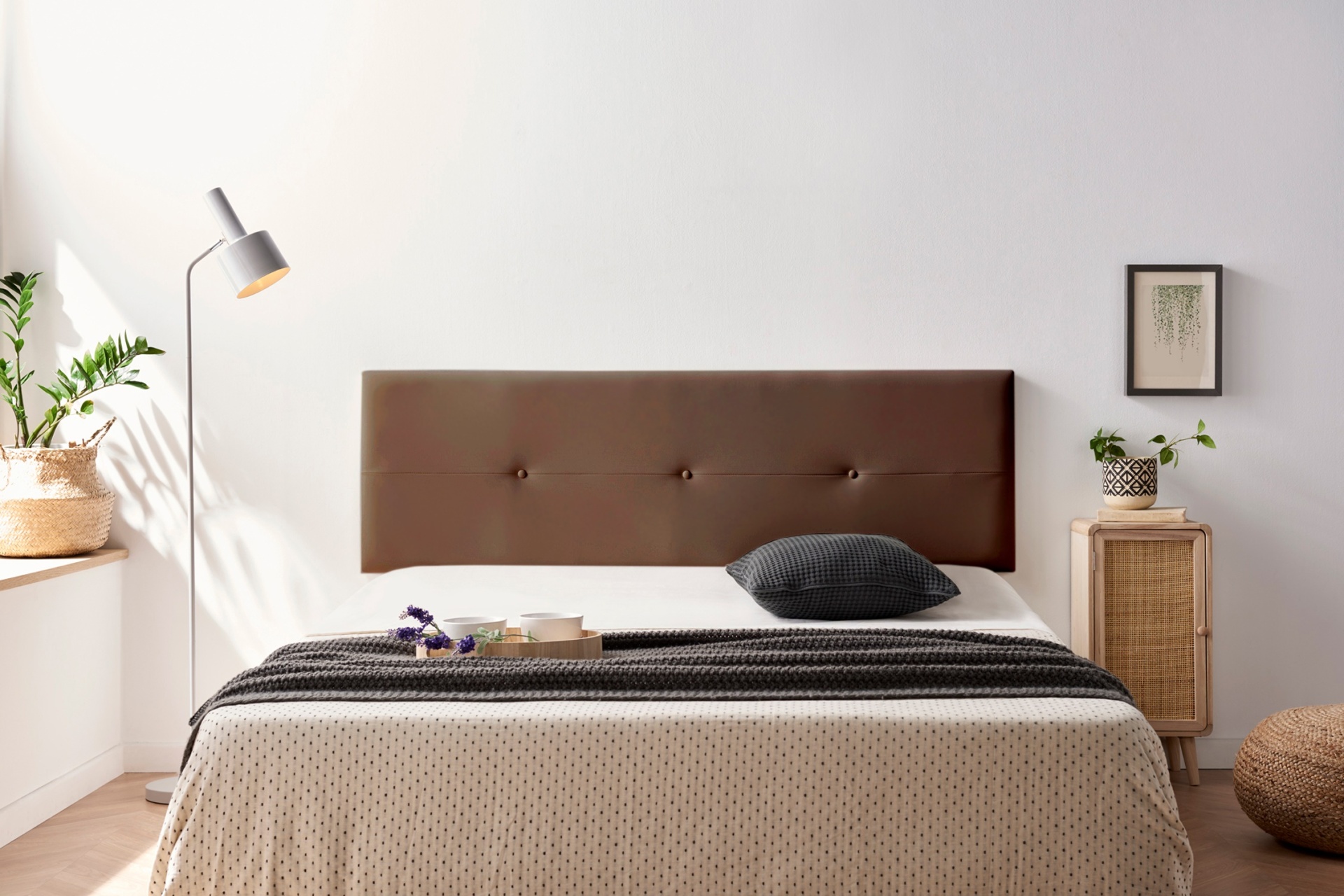 Quarto moderno com cama de casal, cabeceira marrom, roupa de cama bege e acessórios cinzentos