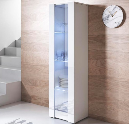 Vitrine de chão Koi V5 com Luz LED - Disponível em 5 cores Móvel vitrina branco com porta de vidro em ambiente com parede de madeira e relógio de parede
