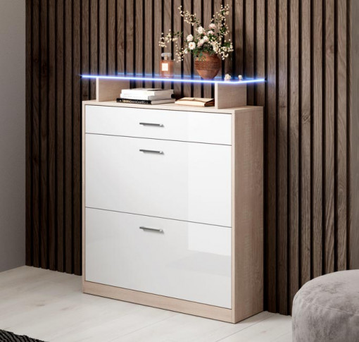 Móvel branco brilhante com três gavetas e decoração com vaso de flores e livros