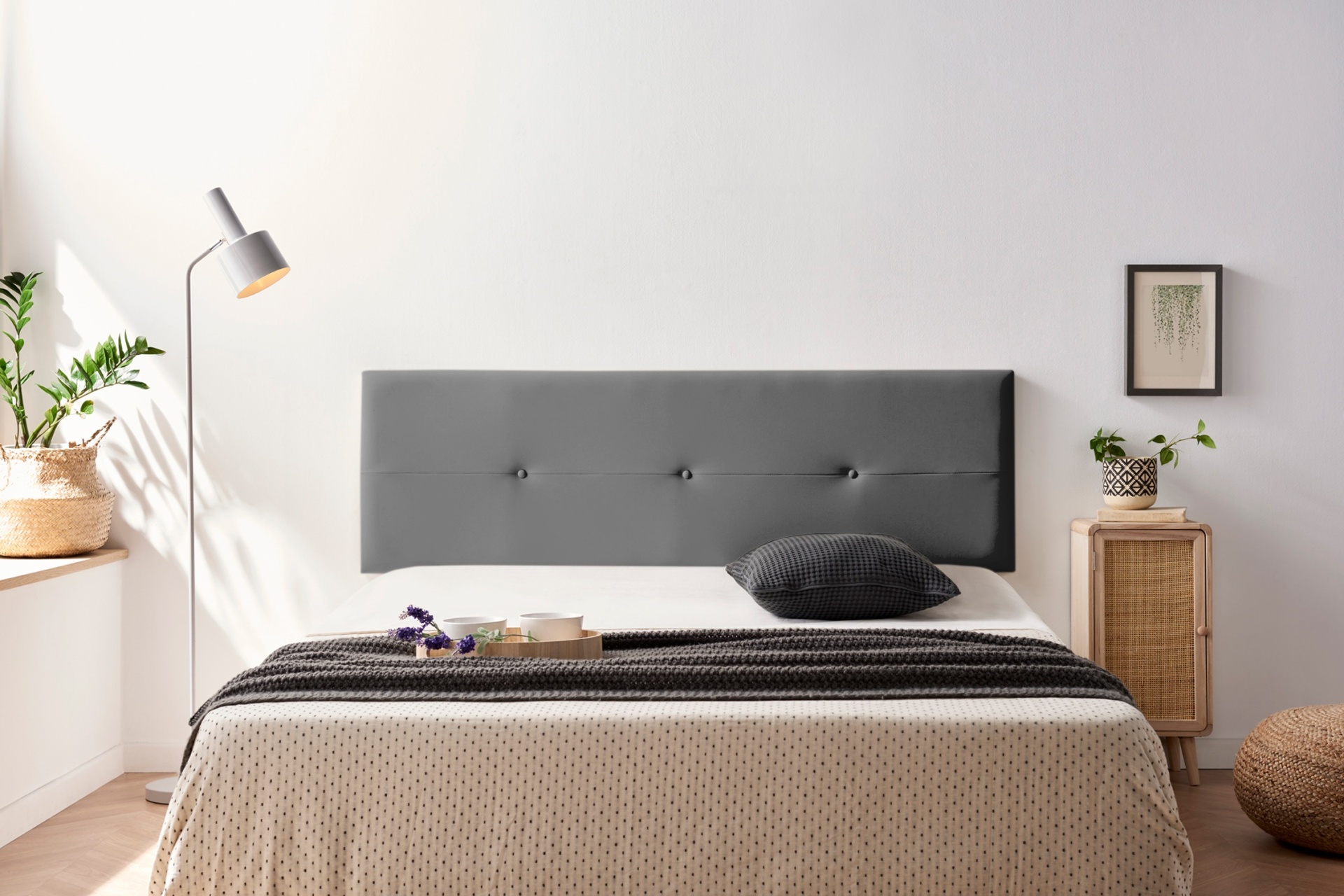 Cabeceira de cama cinzenta estofada com cama arrumada em quarto minimalista