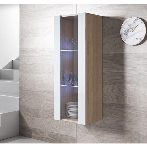 Móvel de parede em madeira clara com portas de vidro contendo copos e pratos, relógio redondo branco em parede de madeira clara