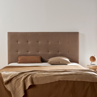 Quarto com cama de casal com cabeceira estofada castanha e roupa de cama em tons castanhos