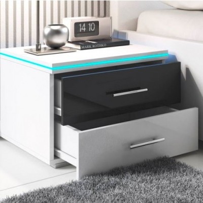 Mesa de cabeceira branca e preta com gavetas abertas e iluminação azul, relógio digital e objeto decorativo prateado em cima