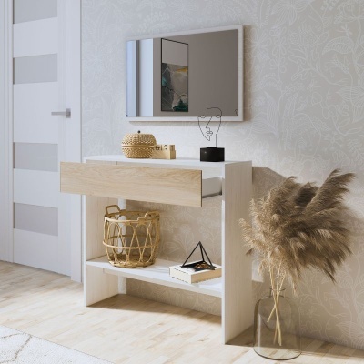 Aparador moderno em madeira clara e branca com decoração e vaso com folhas secas ao lado.