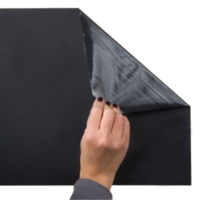 Folha preta com lados brilhante e fosco sendo segurada por uma mão