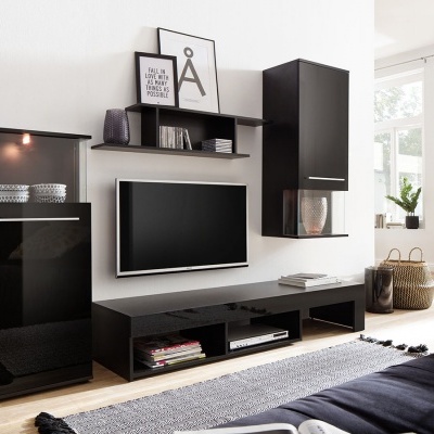 Conjunto de móveis de sala pretos brilhantes numa sala moderna com decoração minimalista e bicicleta ao fundo