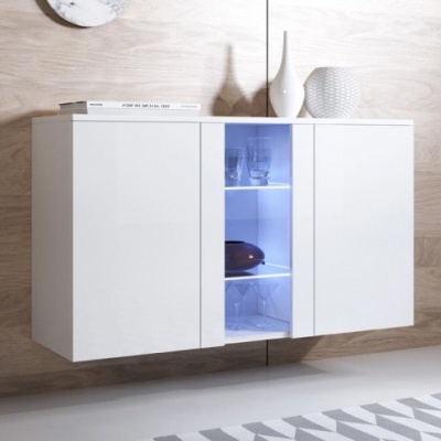 Móvel suspenso branco com porta de vidro iluminada azul no centro, copos dentro e decoração no topo